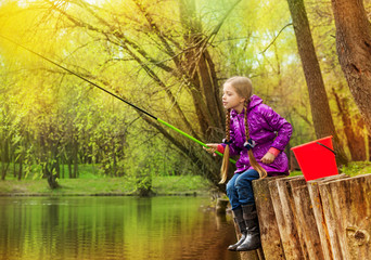 Girl fishing near beautiful pond with fishrod