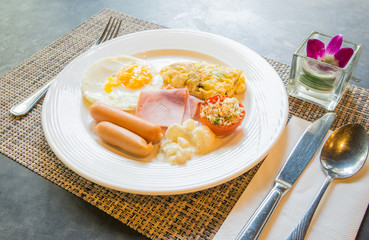 Plate with fried eggs, bacon and chicken sausage