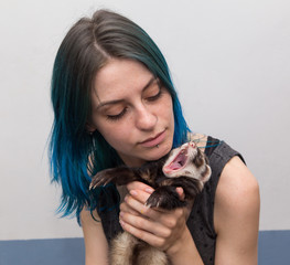 blue haired pretty girl plays with ferret