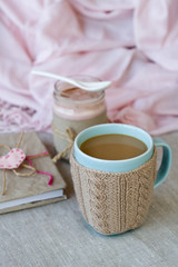 Fototapeta na wymiar Blue cup of coffee in Knitted sweater, homemade berry yogurt