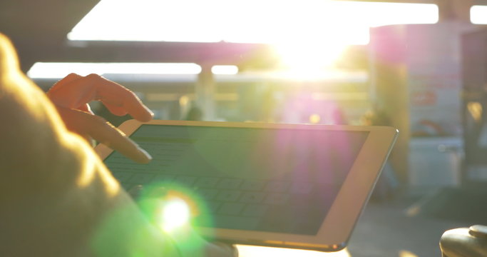 Woman chatting on touch pad in bright sunlight