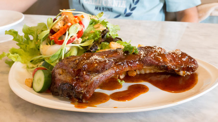 rib steak in white plate with salad