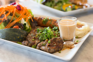 pork steak in white plate with salad