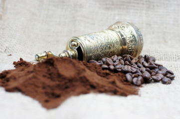 Old coffee grinder with coffee beans and powder