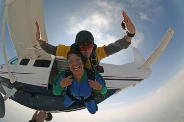Rolgordijnen Skydive tandem exit from the plane  Beautiful smile girl © Mauricio G