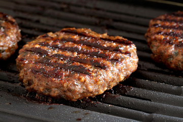 Burgers on grill.
Burgers cooking on a grill.