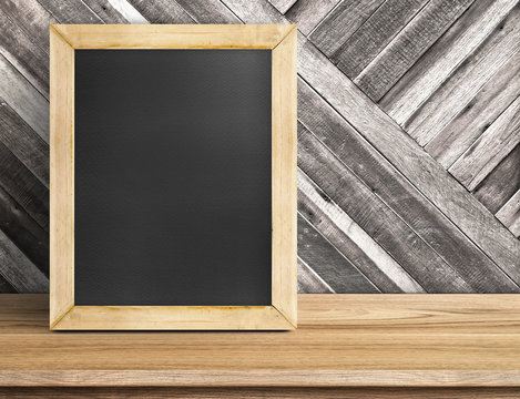 Blank blackboard wood frame on wooden table at diagonal wood wal