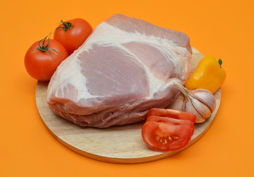 Roast Pork With Vegetables On An Orange Background.