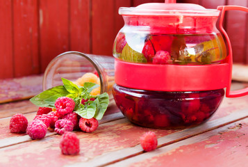 Teapot with mint and red raspberries