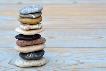 grey black crain zen stones on grey, blue, knotted old wooden background with emty space