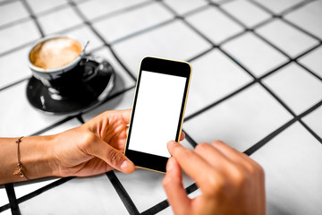 Using phone with coffee on background
