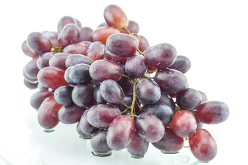 Wet cluster of grapes on a glass table