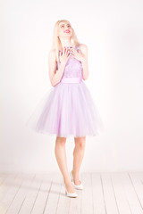 Beautiful happy woman with blond hair, red lips in the studio