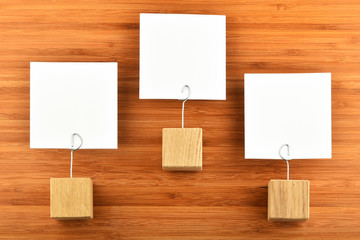 Three paper notes with holders isolated bamboo wooden background