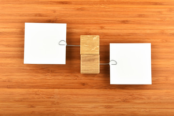 Two paper notes with holders in different directions on wood