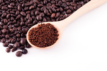 Coffee beans and ground coffee on wooden spoon isolated on white