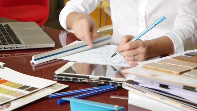 Asian woman interior designer working and typing on laptop computer keyboard. 