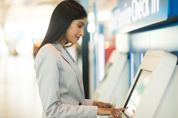 young business traveller using self service check in