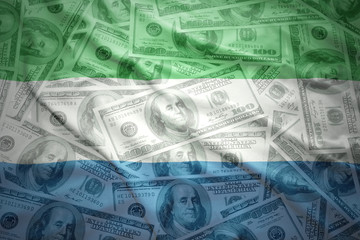 colorful waving sierra leone flag on a american dollar money background