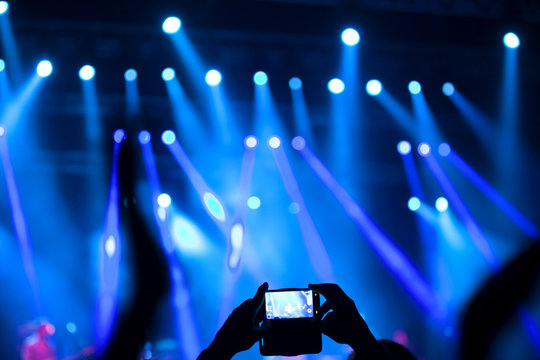 People at rock concert taking photos with cell phone