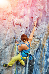Rock climber climbing up a cliff