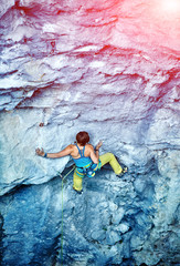 Rock climber climbing up a cliff