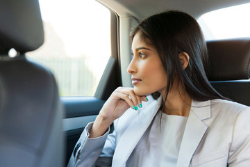 indian business woman sitting in car backseat