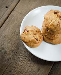 Chocolate chip cookies on white disk on wooden table