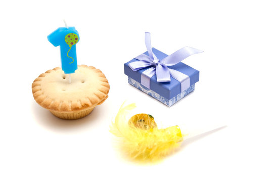 cupcake with one years birthday candle, gift and whistle