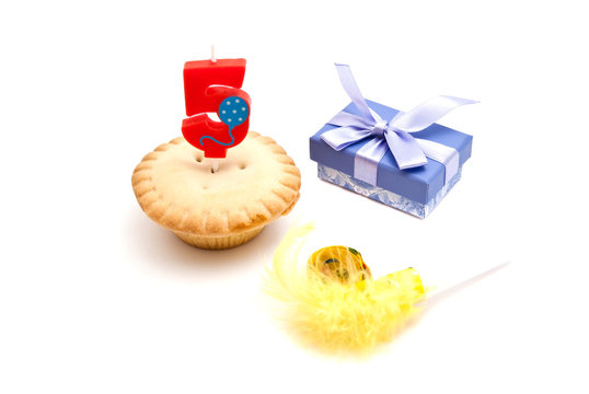 cupcake with five years birthday candle, gift and whistle on whi