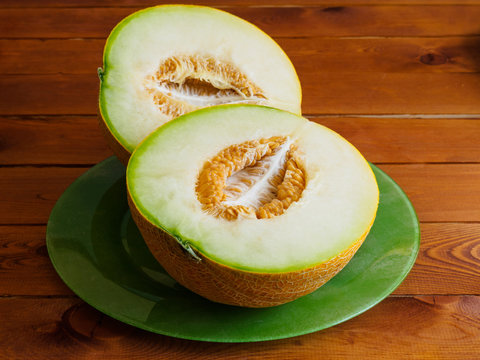 Two halves of a melon on green plate