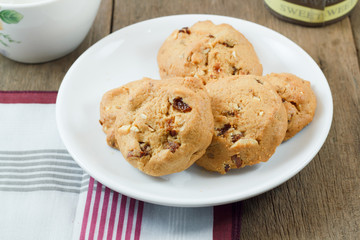 Chocolate chip cookies on white disk on wooden table