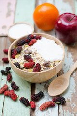 breakfast : home made yogurt with oat flakes  in bowl on wooden