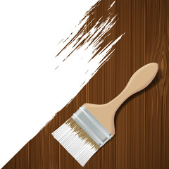 Paintbrush with white paint on a wooden surface.