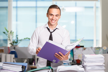Happy office worker works with folders of paper