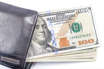 One hundred dollar banknotes in black leather wallet on white ba