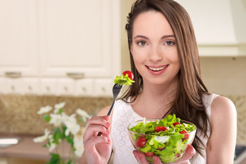 beautiful girl with salad in kitchen