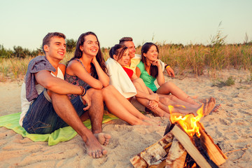 smiling friends in sunglasses on summer beach