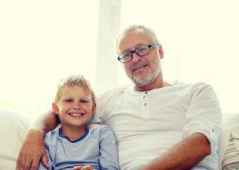 smiling grandfather and grandson at home