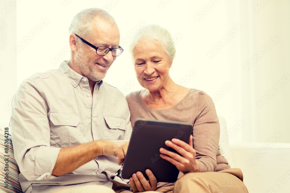 Poster happy senior couple with tablet pc at home