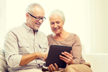 happy senior couple with tablet pc at home