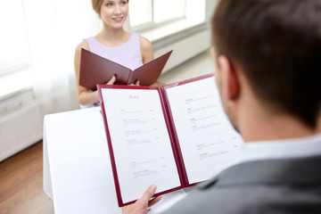 close up of couple with menu at restaurant