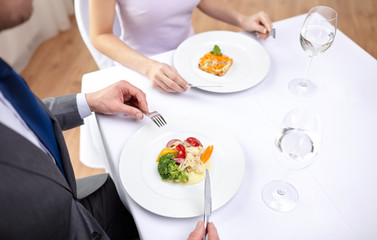 close up of couple eating appetizers at restaurant