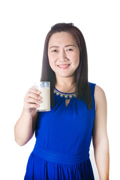 Happy Asian woman with glass of milk in hand isolated on white b