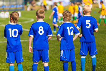 Fototapeta premium Football soccer match for children. Kids waiting on a bench.
