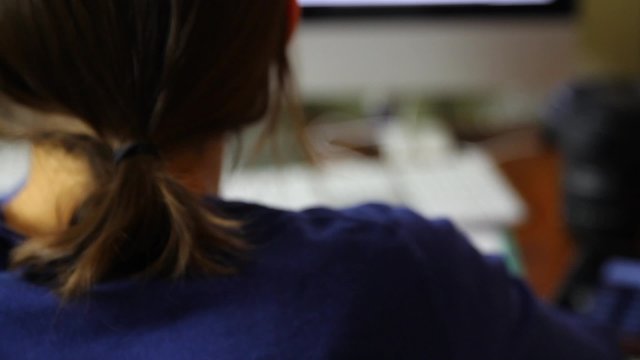 a woman works at home office on computer and ipad