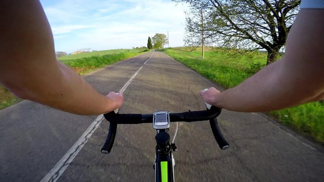 man on bike in a tuscany road in sunset. Original point of view, POV