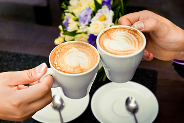 Man and woman's hands and coffee cups