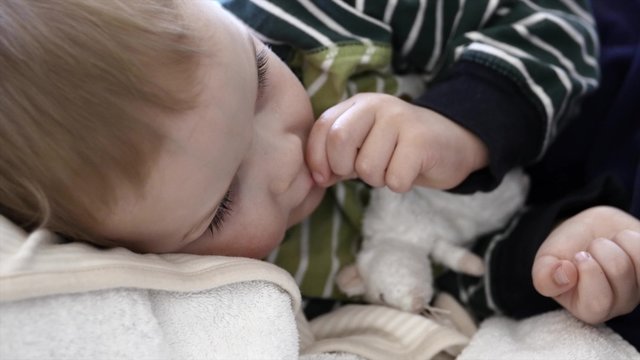 A child boy with the flu on the floor panning shot