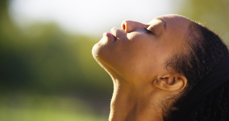 Beautiful black woman feeling the sun on her face